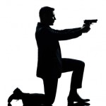 silhouette man kneeling aiming gun